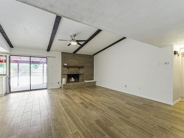 3146 Oak Hill Rd, Carrollton, TX 75007 - unfurnished living room featuring a ceiling fan, wood finished floors, a textured ceiling, baseboards, and a large fireplace