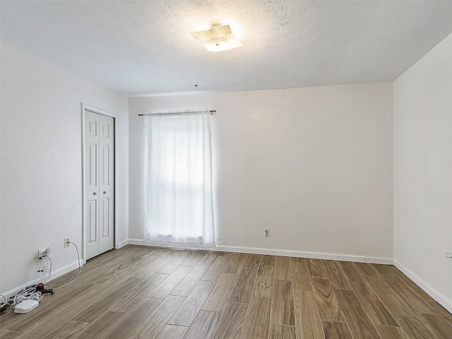 3146 Oak Hill Rd, Carrollton, TX 75007 - empty room featuring wood finished floors, baseboards, and a textured ceiling