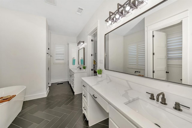 277 Schneider Rd, Sherman, TX 75090 - full bath with a freestanding tub, two vanities, and baseboards