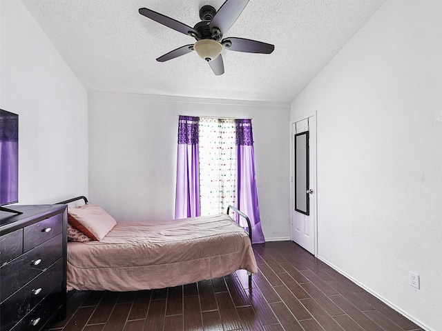 2501 Dahlia Dr, Fort Worth, TX 76123 - bedroom featuring a textured ceiling, dark wood-style flooring, and a ceiling fan