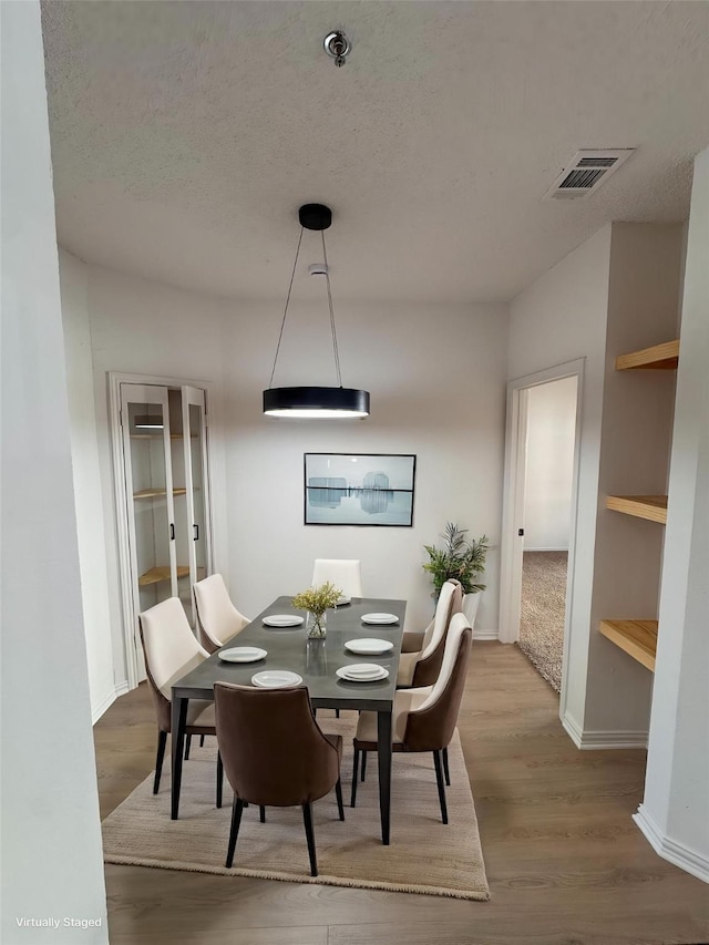 4800 W Lovers Ln Unit 212, Dallas, TX 75209 - dining space with wood finished floors, a textured ceiling, and baseboards
