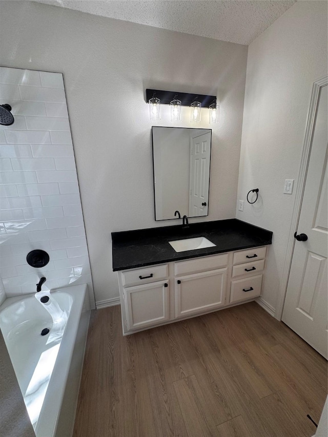 4800 W Lovers Ln Unit 212, Dallas, TX 75209 - bathroom with wood finished floors, vanity, shower / bathtub combination, and a textured ceiling