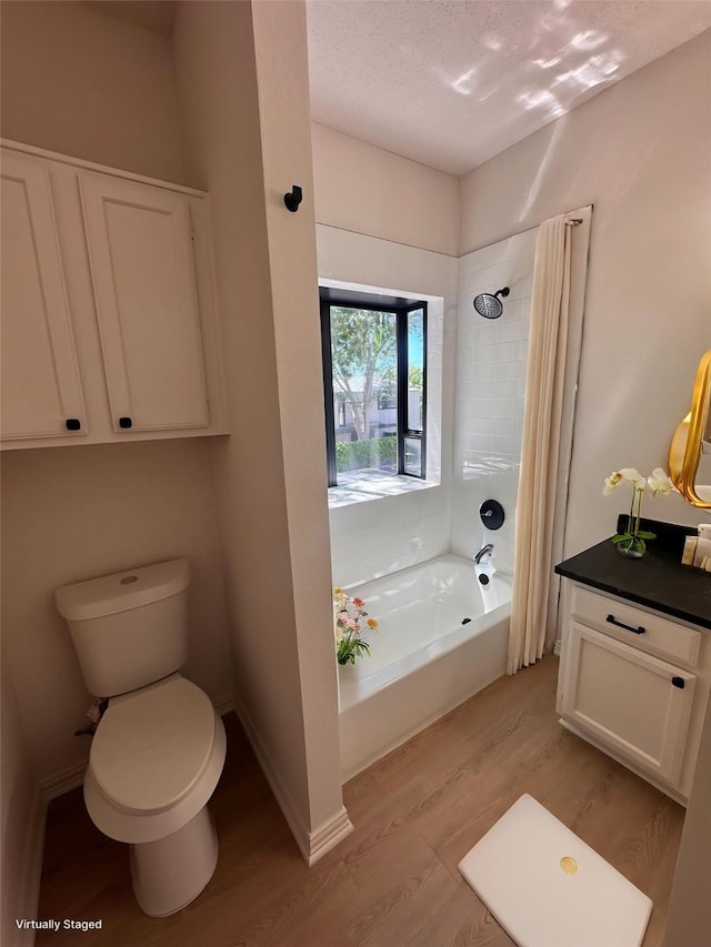 4800 W Lovers Ln Unit 212, Dallas, TX 75209 - bathroom with wood finished floors, toilet, shower / washtub combination, vanity, and a textured ceiling