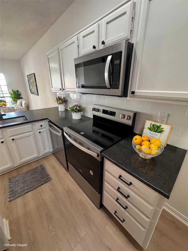 4800 W Lovers Ln Unit 212, Dallas, TX 75209 - kitchen with stainless steel appliances, a sink, light wood finished floors, backsplash, and white cabinets