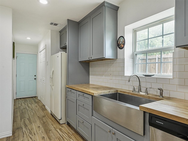 2522 W Jefferson Blvd, Dallas, TX 75211 - kitchen with wood counters, white refrigerator with ice dispenser, gray cabinets, dishwasher, and tasteful backsplash