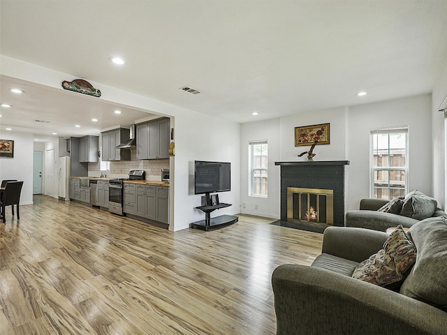 2522 W Jefferson Blvd, Dallas, TX 75211 - living room with recessed lighting, light wood-style flooring, a fireplace, and baseboards