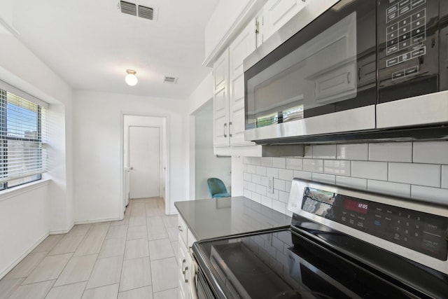 6319 Leasa Ct, Sachse, TX 75048 - kitchen featuring appliances with stainless steel finishes, tasteful backsplash, white cabinetry, light tile patterned floors, and baseboards