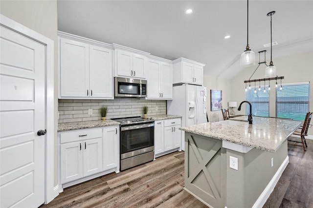 4817 Enclave Dr, Sanger, TX 76266 - kitchen featuring appliances with stainless steel finishes, a sink, wood finished floors, decorative backsplash, and white cabinetry