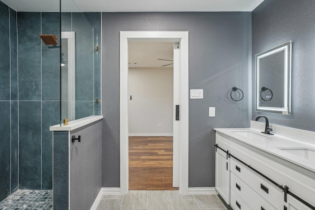 3804 Kathryn Way, Mckinney, TX 75070 - bathroom with double vanity, a walk in shower, a textured wall, and baseboards