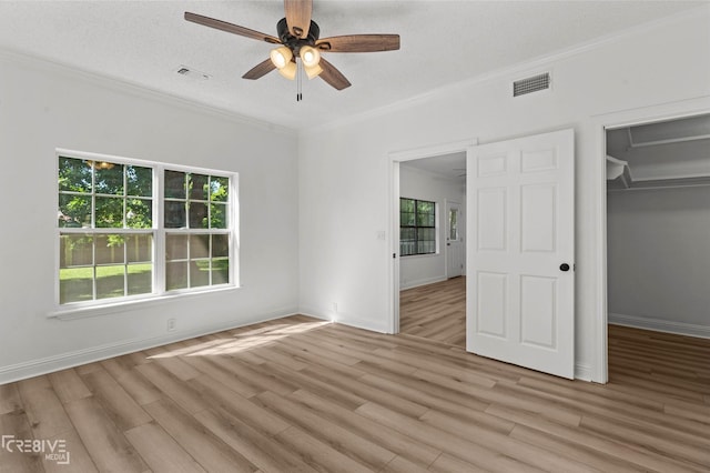 123 Carrollton Ave, Shreveport, LA 71105 - unfurnished bedroom with light wood finished floors, crown molding, baseboards, a walk in closet, and a closet
