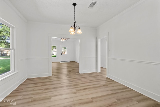 123 Carrollton Ave, Shreveport, LA 71105 - unfurnished dining area with a chandelier, healthy amount of natural light, light wood-type flooring, ornamental molding, and a textured ceiling