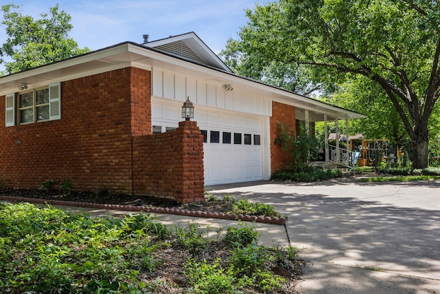 4309 Bilglade Rd, Fort Worth, TX 76109 - view of side of property with a garage, brick siding, driveway, and board and batten siding