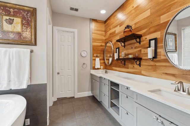 15198 Woodbluff Dr, Frisco, TX 75035 - bathroom featuring wood walls, double vanity, a soaking tub, tile patterned flooring, and recessed lighting