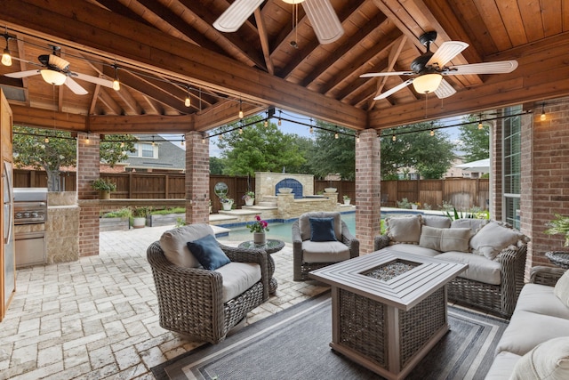 15198 Woodbluff Dr, Frisco, TX 75035 - fenced backyard featuring ceiling fan, a gazebo, an outdoor living space with a fire pit, an outdoor kitchen, and a patio area