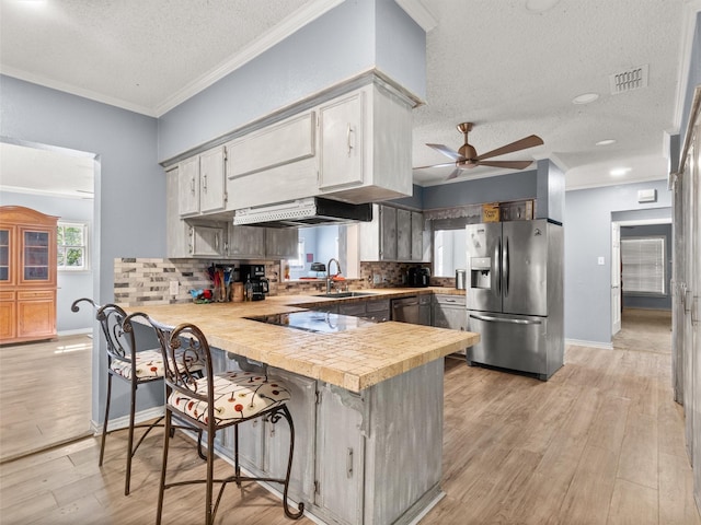 1101 N Bledsoe St, Gilmer, TX 75644 - kitchen featuring black appliances, a peninsula, a textured ceiling, a sink, and light countertops