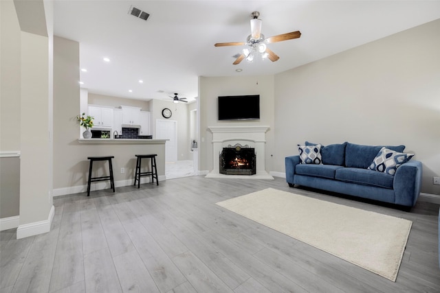 414 Long Cove Dr, Fairview, TX 75069 - living area with ceiling fan, a warm lit fireplace, baseboards, light wood-style flooring, and recessed lighting