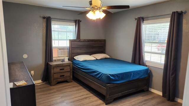 809 Bowie St, Sweetwater, TX 79556 - bedroom featuring light wood-type flooring, baseboards, a ceiling fan, and cooling unit