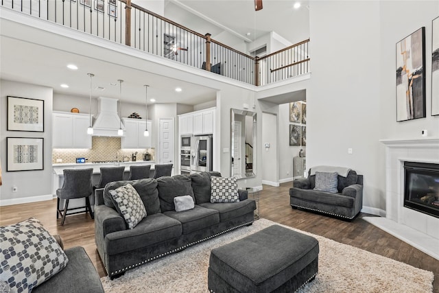 3456 Begonia Ln, Irving, TX 75038 - living area featuring wood finished floors, a glass covered fireplace, a high ceiling, recessed lighting, and baseboards