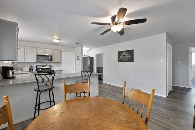 1429 W Water St, Weatherford, TX 76086 - dining room with a ceiling fan, dark wood-style flooring, and baseboards