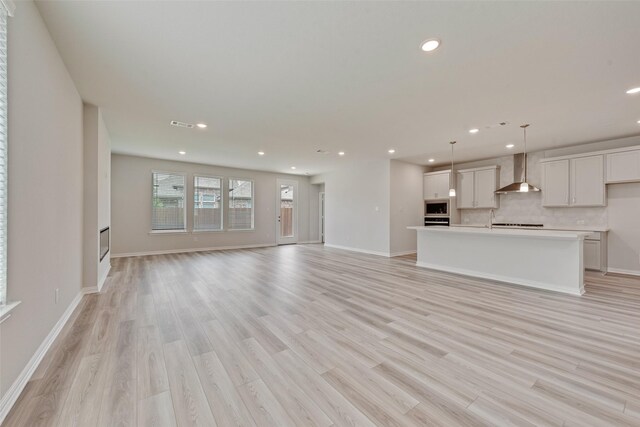 3404 Riverlawn Dr, Anna, TX 75409 - unfurnished living room with recessed lighting, light wood-style floors, and baseboards