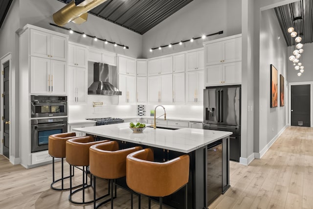 1210 Berger Rd, Temple, TX 76501 - kitchen with high end black refrigerator, wall chimney exhaust hood, a sink, beverage cooler, and tasteful backsplash