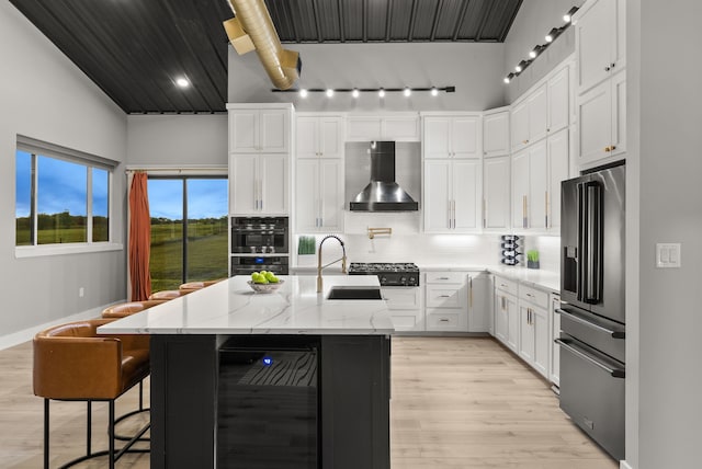 1210 Berger Rd, Temple, TX 76501 - kitchen with high end fridge, wall chimney range hood, beverage cooler, a sink, and track lighting