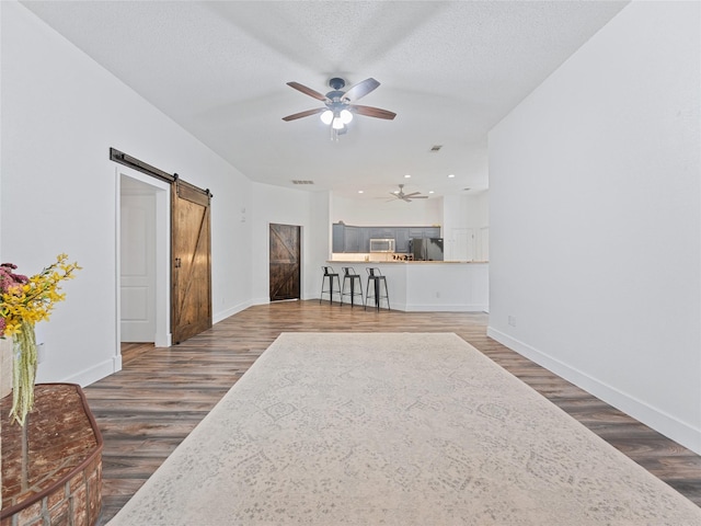 12200 Rolling Ridge Dr, Fort Worth, TX 76028 - living room with a barn door, ceiling fan, baseboards, wood finished floors, and recessed lighting