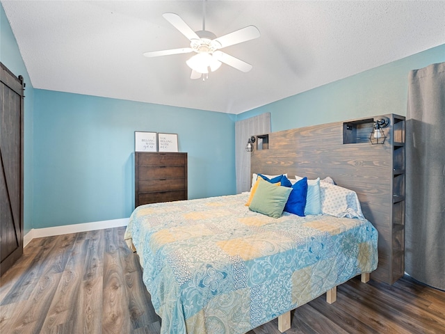 12200 Rolling Ridge Dr, Fort Worth, TX 76028 - bedroom with wood finished floors, a barn door, baseboards, and a ceiling fan