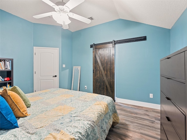 12200 Rolling Ridge Dr, Fort Worth, TX 76028 - bedroom with lofted ceiling, a barn door, wood finished floors, a ceiling fan, and baseboards