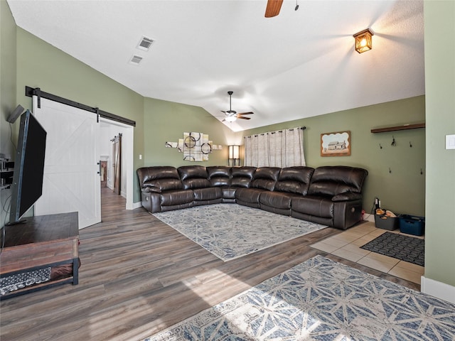 12200 Rolling Ridge Dr, Fort Worth, TX 76028 - living area featuring a ceiling fan, a barn door, vaulted ceiling, wood finished floors, and baseboards