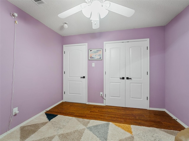 12200 Rolling Ridge Dr, Fort Worth, TX 76028 - bedroom with a closet, ceiling fan, baseboards, wood finished floors, and a textured ceiling