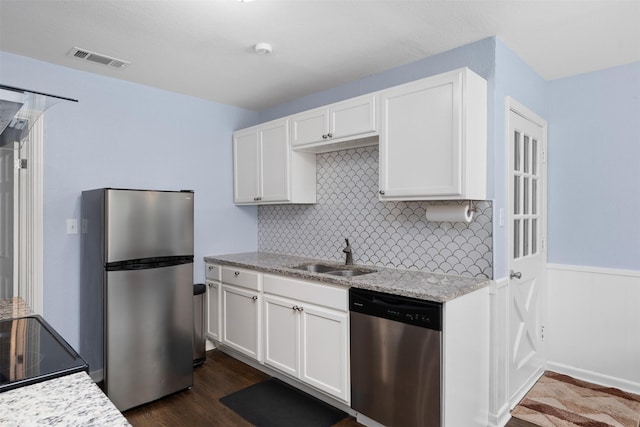 1701 Lawther Dr, River Oaks, TX 76114 - kitchen with stainless steel appliances, a sink, white cabinetry, backsplash, and light stone counters