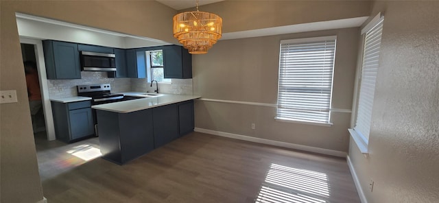 6648 Inwood Dr, Watauga, TX 76148 - kitchen with stainless steel appliances, decorative backsplash, wood finished floors, and baseboards