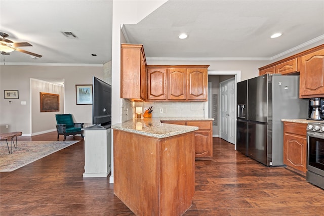 10161 Aragon Dr, Waco, TX 76708 - kitchen with stainless steel appliances, a ceiling fan, decorative backsplash, brown cabinetry, and light stone countertops