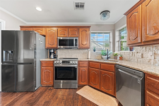10161 Aragon Dr, Waco, TX 76708 - kitchen with appliances with stainless steel finishes, a sink, dark wood finished floors, crown molding, and light stone counters