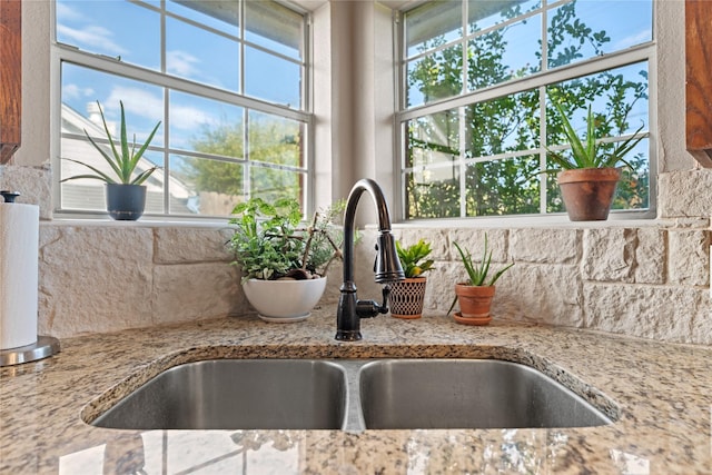 10161 Aragon Dr, Waco, TX 76708 - kitchen view of a sink, backsplash, and light stone countertops