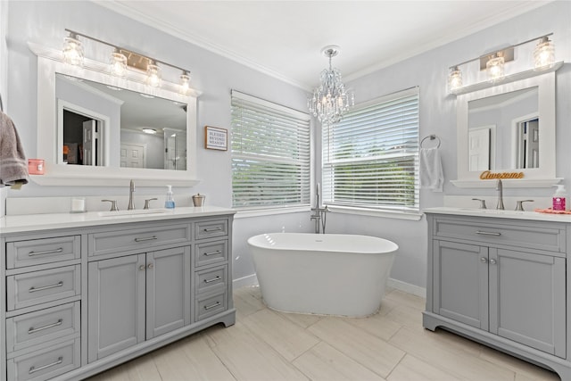 10161 Aragon Dr, Waco, TX 76708 - bathroom with two vanities, a freestanding tub, ornamental molding, a chandelier, and baseboards