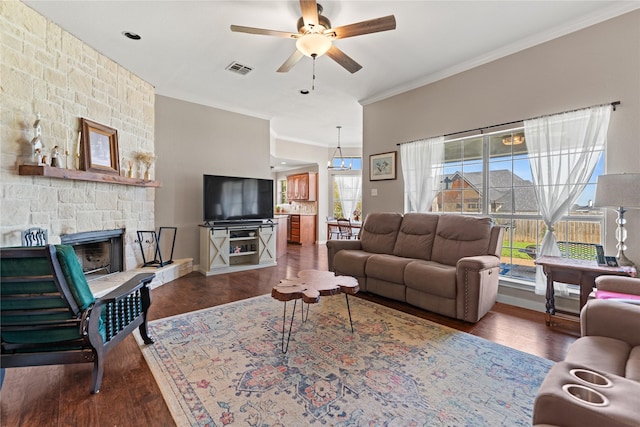 10161 Aragon Dr, Waco, TX 76708 - living room with ornamental molding, wood finished floors, a ceiling fan, a stone fireplace, and baseboards