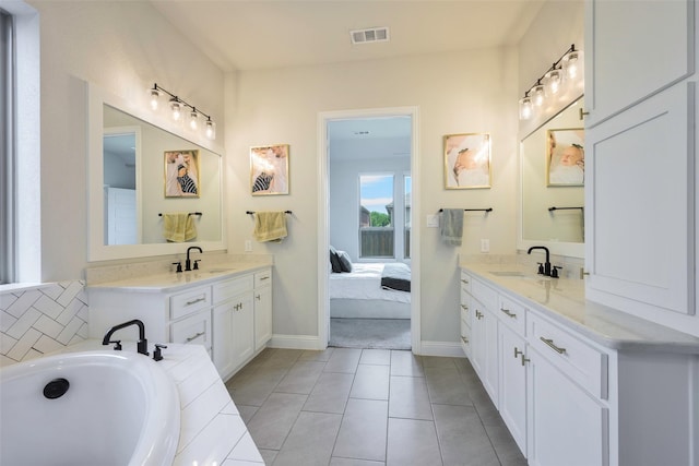 3812 Ironbark Way, Mckinney, TX 75071 - full bathroom featuring connected bathroom, two vanities, a tub, and baseboards