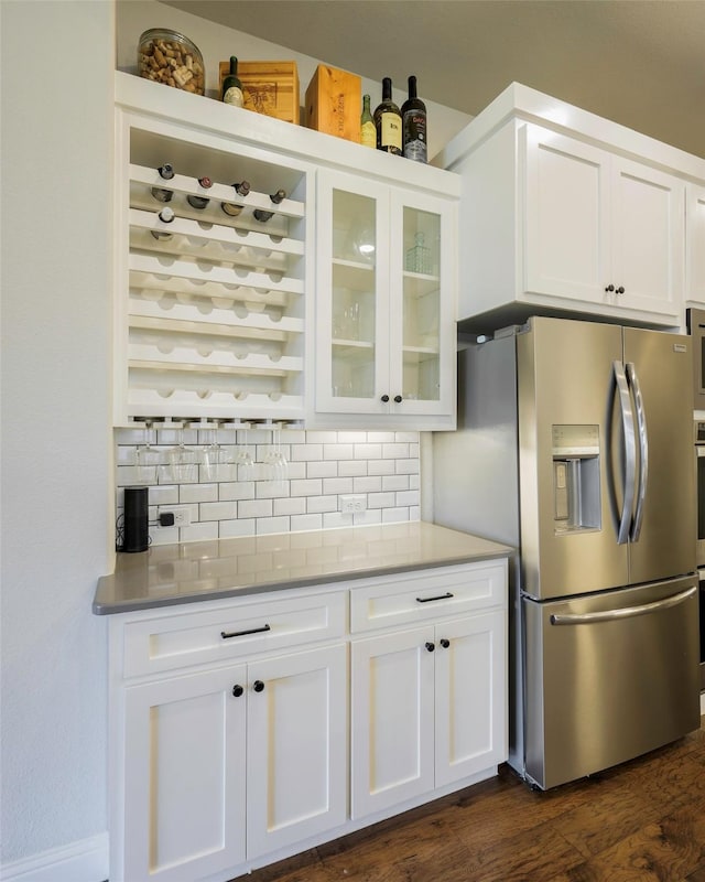 3812 Ironbark Way, Mckinney, TX 75071 - kitchen featuring stainless steel fridge, tasteful backsplash, glass insert cabinets, and white cabinetry