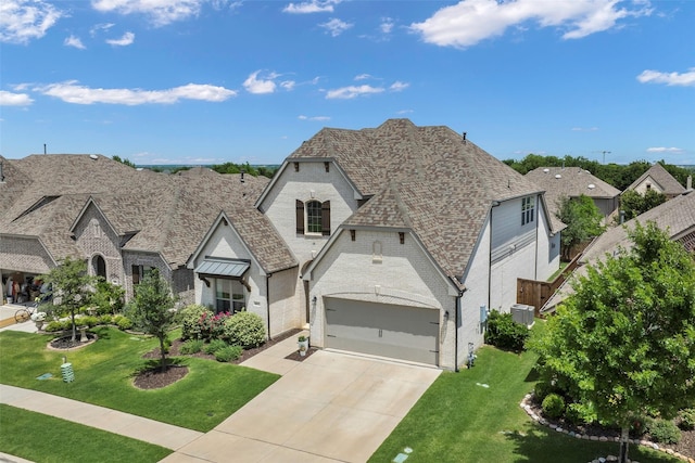 3812 Ironbark Way, Mckinney, TX 75071 - french country style house featuring brick siding, concrete driveway, an attached garage, a front lawn, and a shingled roof