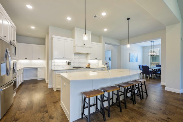 3812 Ironbark Way, Mckinney, TX 75071 - kitchen featuring a sink, dark wood-type flooring, tasteful backsplash, light stone counters, and a kitchen island with sink
