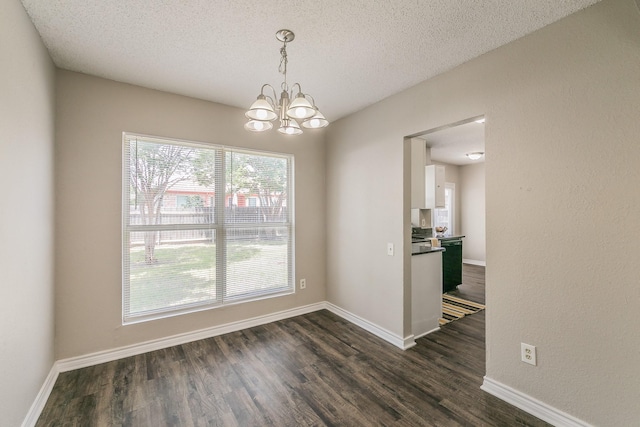 3733 River Birch Rd, Fort Worth, TX 76137 - unfurnished dining area featuring a chandelier, dark wood-type flooring, a textured ceiling, and baseboards