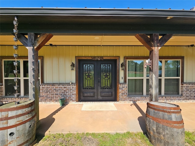 437 County Road 3190, Winnsboro, TX 75494 - property entrance featuring brick siding, french doors, a porch, and board and batten siding