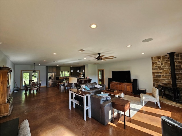 437 County Road 3190, Winnsboro, TX 75494 - living room featuring a wood stove, recessed lighting, ceiling fan, finished concrete floors, and baseboards