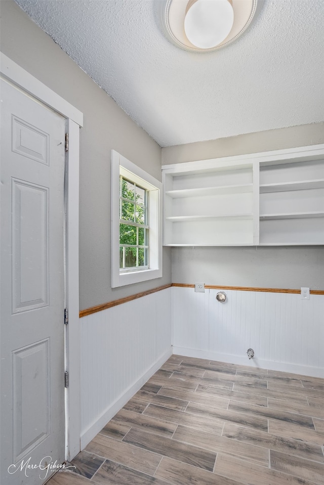 2383 Julia St, Bossier City, LA 71112 - washroom featuring wood finished floors, a wainscoted wall, and a textured ceiling