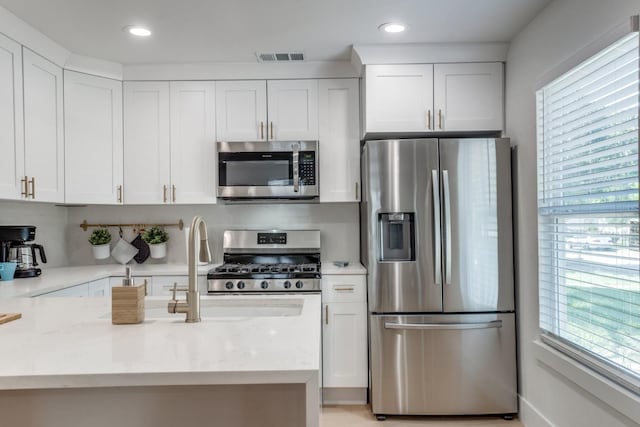 1614 Engle Ave, Dallas, TX 75224 - kitchen featuring stainless steel appliances, white cabinetry, light stone countertops, and recessed lighting