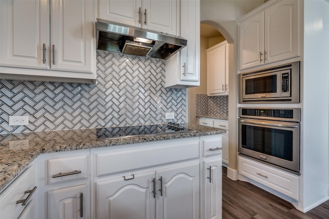 2828 Pino, Grand Prairie, TX 75054 - kitchen featuring appliances with stainless steel finishes, ventilation hood, tasteful backsplash, white cabinets, and light stone countertops