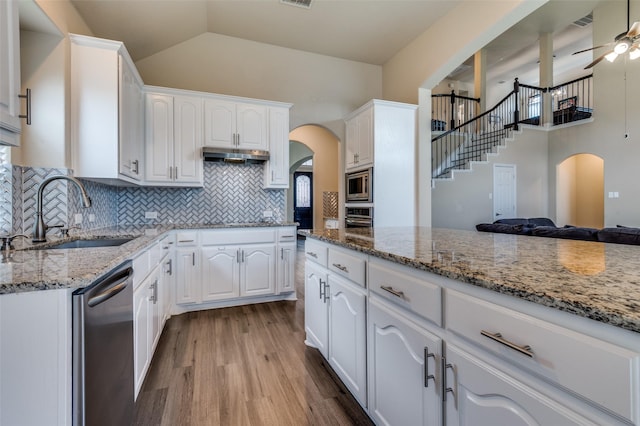 2828 Pino, Grand Prairie, TX 75054 - kitchen with stainless steel appliances, arched walkways, wood finished floors, ceiling fan, and light stone countertops
