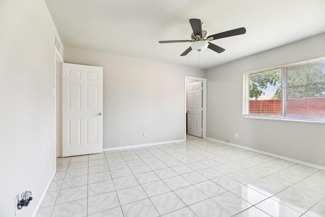 5001 N Colony Blvd, The Colony, TX 75056 - unfurnished bedroom with baseboards, light tile patterned floors, and a ceiling fan